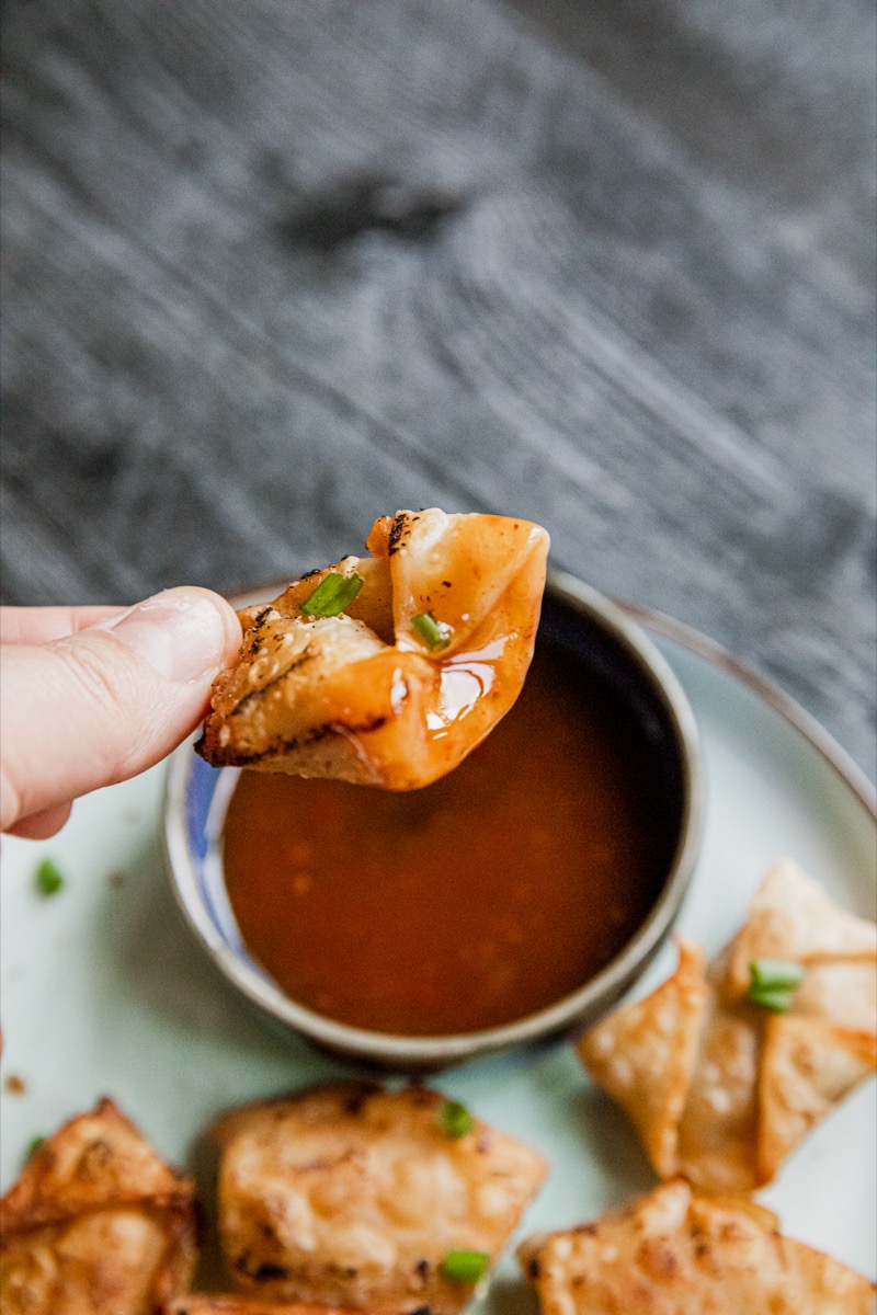 Fried Pork Dumplings being dipped into sauce